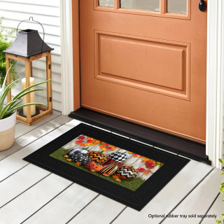 Black doormat with Patterned Pumpkins design on a porch in front of a door.