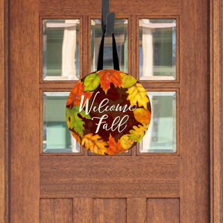 Wooden door hanger with Welcome Fall text and colorful autumn leaves design on round wood surface.