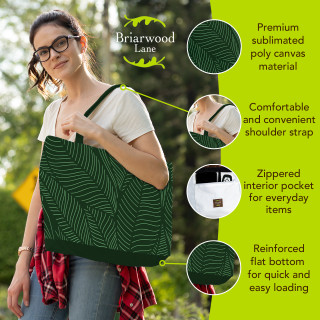 Woman holding large dark green Tropical Leaves Canvas Tote bag with white leaf pattern and straps.