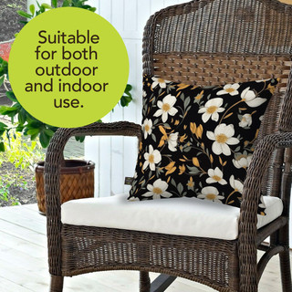 Elegant Flowers Burlap Pillow with white flowers and yellow centers on black background on wicker chair.