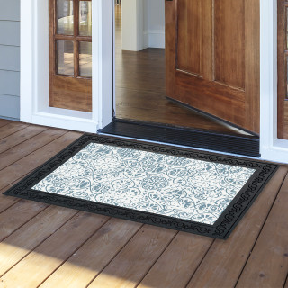 Ornamental blue and white doormat on wooden porch outside open doorway with black border.