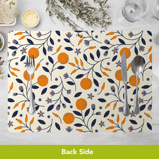Dining placemat with orange, blue and purple floral pattern, silverware on top, white background visible.