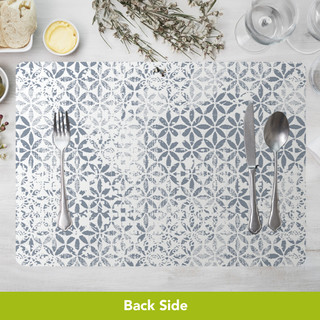 Distressed Elegance Placemat, gray and white floral pattern, 4-pack, on table with utensils and dinnerware.