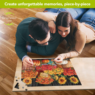 Couple assembling Briarwood Lane Baskets of Mums 1000-piece jigsaw puzzle with sunflowers and mums.
