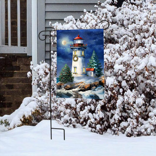 Wonderland Lighthouse Garden Flag with snowy scene and trees on a garden flag stand outside.