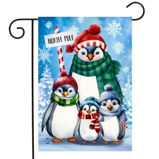 Penguin Family Garden Flag, four penguins in hats and scarves with North Pole sign nearby.