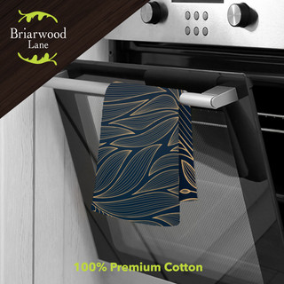 Organic Flow Cotton Hand Towel, blue and gold leaf pattern, hanging on oven handle, cotton material.