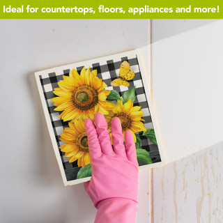 Checkered Sunflowers Summer Swedish Dishcloth with pink glove on white surface, bright yellow flowers.