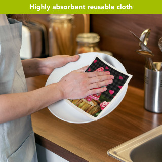 Valentine's Gnomes Swedish Dishcloth, heart-patterned reusable cloth drying white plate in kitchen.