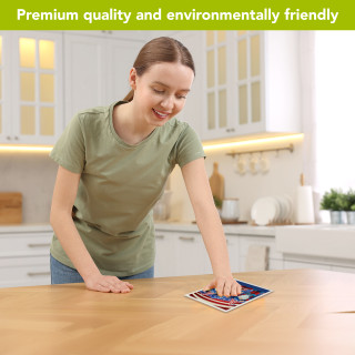 Woman placing Patriotic Gnomes Swedish Dishcloth on a kitchen counter, showcasing eco-friendly cleaning product.