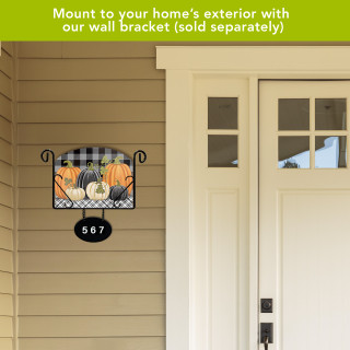 Checkered pumpkins acrylic art sign with house number 567 on exterior wall beside front door.