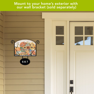 Bountiful Bushel Acrylic Art Sign with floral design, mounted on a house exterior wall bracket.