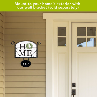 Home acrylic art sign with green wreath and house number 567 on black metal bracket.