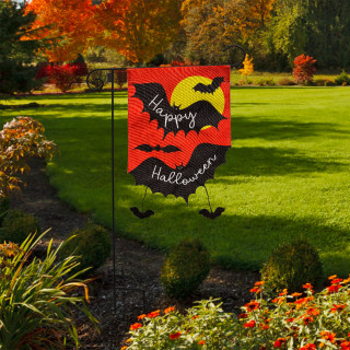 Happy Halloween Bats Burlap Garden Flag with black bats and orange background in a garden.