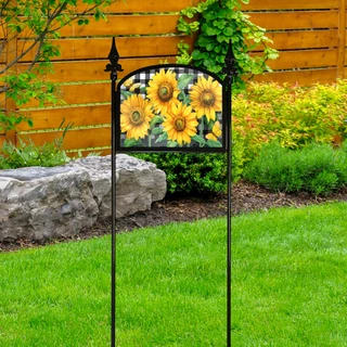 Black wrought iron sign display stake with sunflower design in a garden setting outdoors.