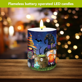 Halloween Gnomes flameless candle with colorful Halloween design and lit LED flame on wooden surface.