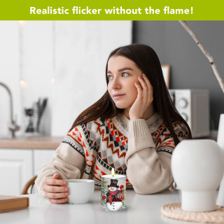 Snowman and Friends Flameless Candle, lit, on table with woman holding a white mug nearby.