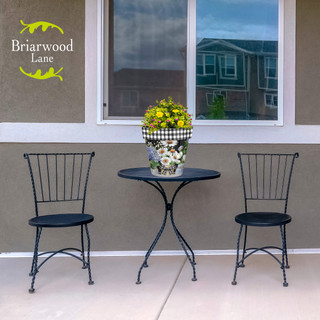 Crated Mason Jars medium planter on outdoor table between two black metal chairs with yellow flowers.