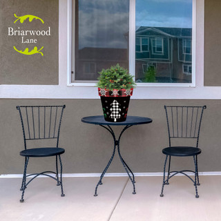 Black metal chairs and table with Checkered Trees Medium Planter and green plant on patio.