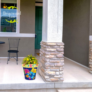 Hello Sunshine Medium Planter, colorful floral pot with yellow flowers on a porch.