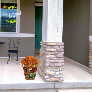 Autumn Farm Medium Planter with vibrant orange flowers on a home's porch with stone pillar nearby.