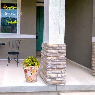 Colorful Flowers Medium Planter with yellow flowers on a stone and white porch floor display.