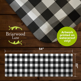 Black and white check oversized comfort mat, 54x22 inches, on dark wood background, waterproof vinyl.