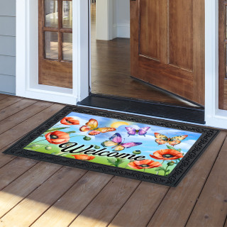 Butterflies and Poppies colorful welcome doormat with black border on wooden porch outside open doorway.