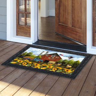 Sunflower Barn Doormat with black border and vibrant sunflower design on wooden porch outside doorway.