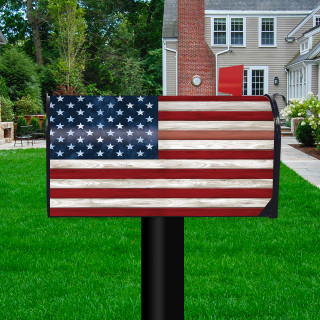 Wood American Flag Oversized Mailbox Cover on a black post in a front yard setting.