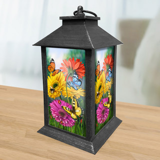 Black metal lantern with colorful butterflies and daisies design on glass panels, vibrant floral pattern.