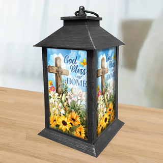 Black metal lantern with floral design and God Bless Our Home text on sides.