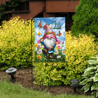 Springtime Gnome Garden Flag with colorful gnome, butterflies, and flowers on a garden stand outdoors.