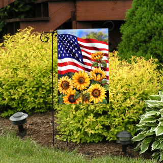 American Sunflowers Garden Flag with USA flag and sunflowers on a black metal stand outdoors.