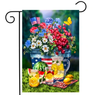 American Lemonade Garden Flag with floral design, lemonade pitcher, and glasses on grass with American flag.