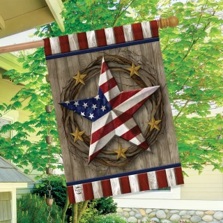American Barn Star House Flag with patriotic star design and wreath on wooden background hanging outdoors.