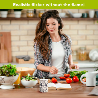 Woodcut Floral Flameless Candle on table beside salad and book in a kitchen setting with woman.