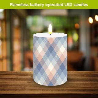 Pink and blue check flameless candle with LED flame on a wooden surface.