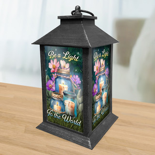 Black metal lantern with colorful floral design and Be a Light To the World text.