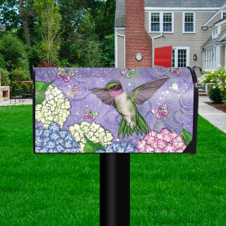 Hummingbird and Hydrangea colorful mailbox cover with purple background and flowers on a black post outdoors.