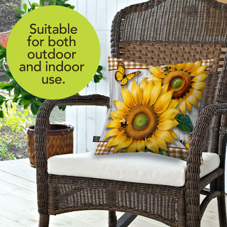Sunflower Duo Indoor/Outdoor Pillow on a wicker chair with a white cushion and brown frame.