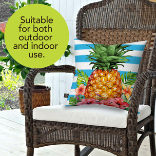 Pineapple and Stripes Indoor/Outdoor Pillow on wicker chair with white cushion and tropical design.