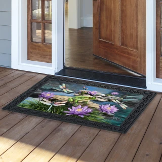 Dragonflies and Frog Doormat with purple flowers and green leaves on a black background outdoors.