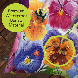 Pansies indoor/outdoor pillow with colorful flowers and premium waterproof burlap material in vibrant purple, pink, orange.