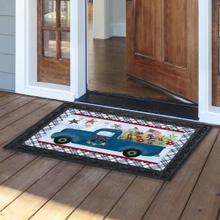 Celebrate America Pickup doormat with blue truck, flowers, and patriotic design on wooden porch floor.