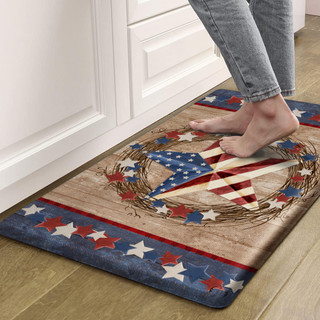 Americana Barnstar Comfort Mat with patriotic stars and flag design on wooden floor beside white cabinet.
