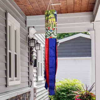 American Flower Field Windsock Wind Twister with blue and red tails hanging from a house eave.