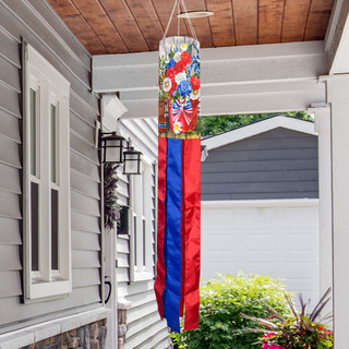 Red White and Beautiful Windsock Wind Twister with colorful floral design and red blue tails hanging outdoors.