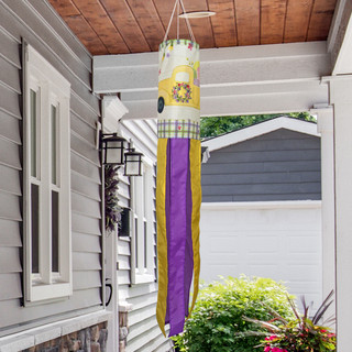 Yellow and purple Happy Easter Pickup Windsock Wind Twister hanging from a porch ceiling outdoors.