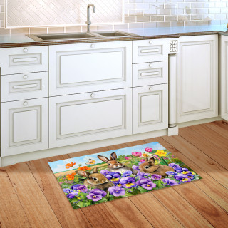 Spring Bunny Trio Doormat on wooden kitchen floor with colorful floral design and three bunnies.